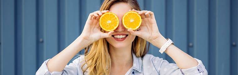 femme blonde oranges devant yeux